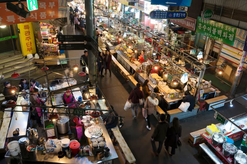 Rows of food stalls and diners at Gwangjang Market seen from above in the evening