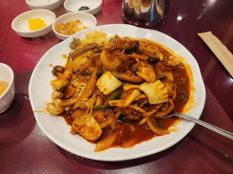 Plate of yaki-udon in Daegu: thick noodles stir-fried with squid, mushrooms and vegetables in a red sauce